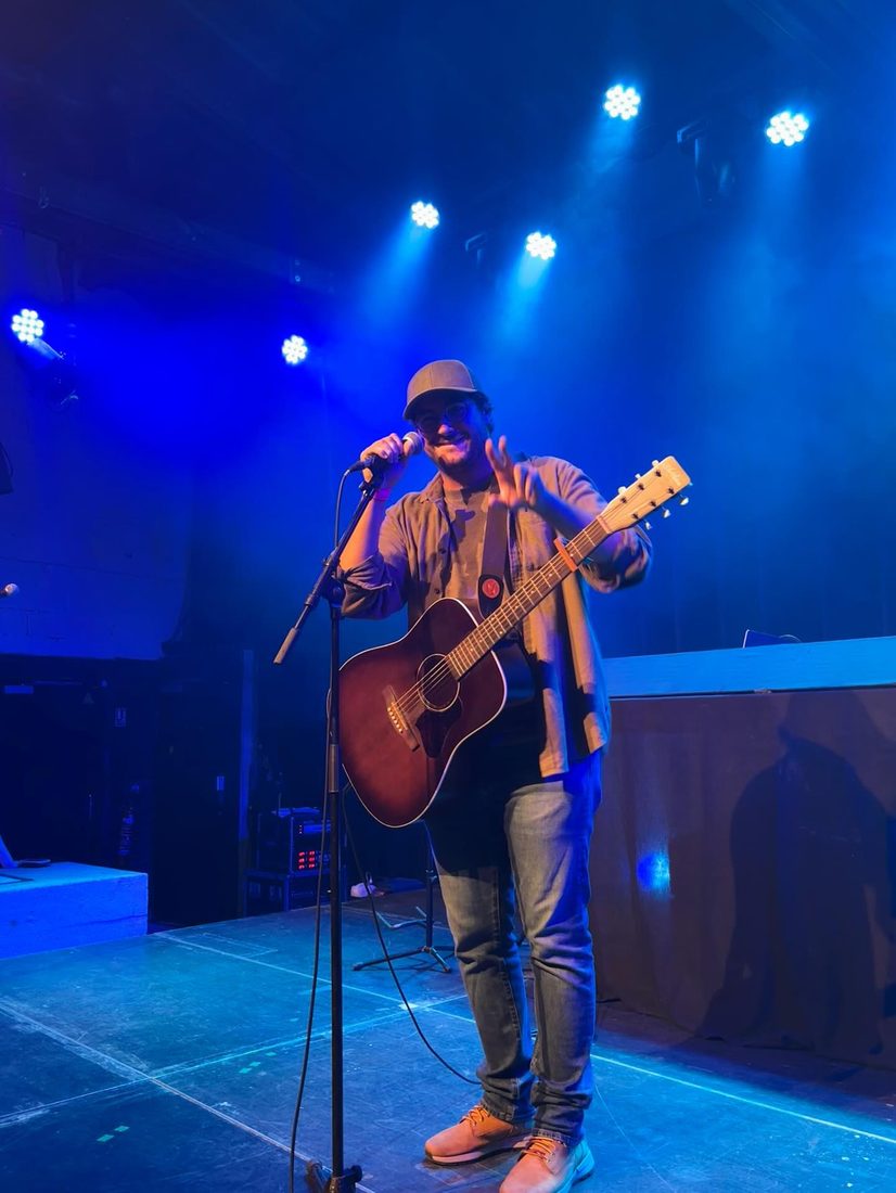 Côme sur scène à La Marbrerie, guitare acoustique, lumière bleue